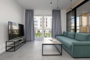 TV a/nebo společenská místnost v ubytování Jasny Apartament z Ogrodem i Parkingiem na Przedmieściach Warszawy by Noclegi Renters