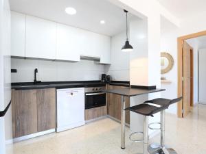 卡耐特蒂贝兰格Contemporaneo y perfecto para sus vacaciones的厨房配有白色橱柜和黑色台面