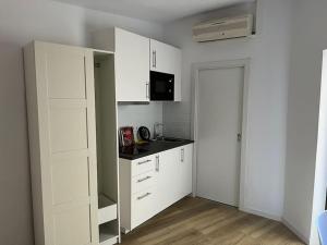 a kitchen with white cabinets and a black counter top at Acogedor piso independiente Valldoreix in Sant Cugat del Vallès