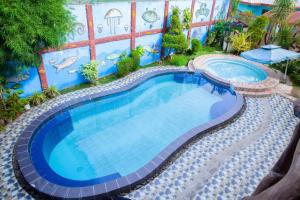 a large swimming pool with a blue wall at Balai La Niña Beach Resort in Carmen
