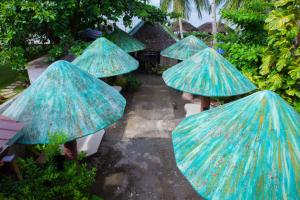 a group of blue umbrellas in a garden at Balai La Niña Beach Resort in Carmen +1 photo