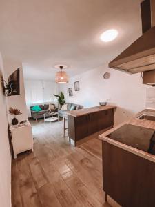 a large kitchen and living room with a couch at Pitayas Apartment in Corralejo