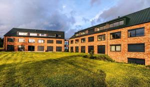 a large brick building with a grassy field next to it at Lakeside Apartmán 111 Lipno in Černá v Pošumaví