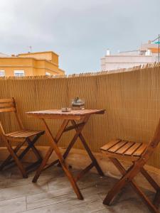a wooden table and two chairs next to a fence at Pitayas Apartment in Corralejo