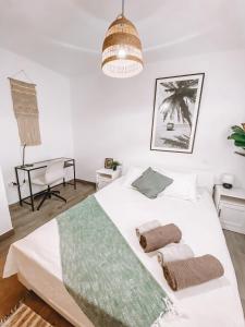 a bedroom with a white bed with two towels on it at Pitayas Apartment in Corralejo