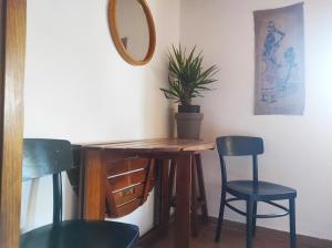 a table with two chairs and a mirror and a plant at Casa da Cabana in Budens