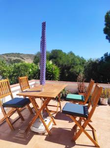 a wooden picnic table and four chairs on a patio at Casa da Cabana in Budens