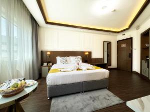 迪拜Fortune Plaza Hotel, Dubai Airport的一间卧室,里面有一张大床和一张桌子。