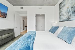 a bedroom with a large white bed with blue pillows at 2bd 2ba Best style and location Pool spa gym pkg! in American Towers Condominium