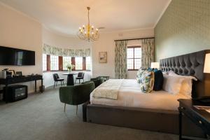 a hotel room with a large bed and a desk at Palm House Boutique Hotel and Spa in Cape Town