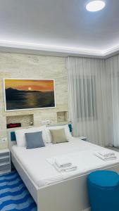ein Schlafzimmer mit einem großen weißen Bett in einem Zimmer in der Unterkunft Reana Apartament Dhermi beach in Dhërmi + 19 Fotos