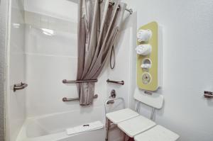 een badkamer met een toilet, een bad en een kruk bij Motel 6-Colby, KS in Colby