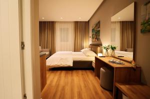 a hotel room with a bed and a desk at Theatro Hotel Apartaments Tirana in Tirana