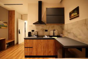 a kitchen with a black counter top and wooden cabinets at Theatro Hotel Apartaments Tirana in Tirana