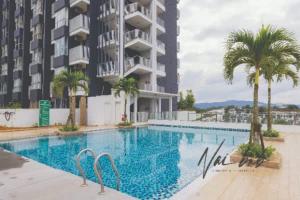a swimming pool with palm trees and a building at NaiBnB in Nadayu 63 in Kuala Lumpur