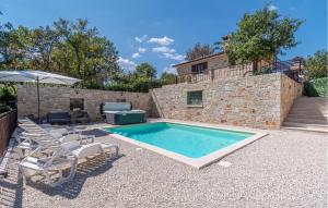 basen na dziedzińcu z krzesłami i parasolem w obiekcie Stunning Home In Trosti w mieście Rojnići