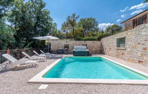basen na dziedzińcu z krzesłami i parasolem w obiekcie Stunning Home In Trosti w mieście Rojnići