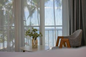 a vase of flowers on a table in front of a window at sunny islander diving resort in Looc