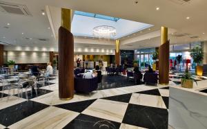 a lobby of a hotel with tables and chairs at The Sydney Hotel in Bologna
