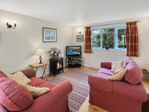 a living room with two couches and a tv at Forge Cottage in Minehead