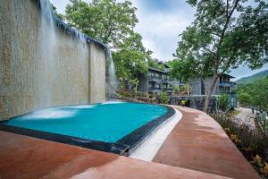una piscina con cascata accanto a un muro di Kananwas Resort, Kumbhalgarh a Kumbhalgarh
