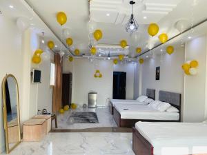a room with two beds with yellow balloons on the ceilings at golden mask pyramids view in Cairo