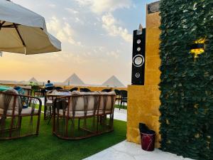 a table with chairs and a speaker next to a wall at golden mask pyramids view in Cairo
