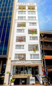 a white building with flower boxes on the windows at Happy Day Riverside Hotel & Spa Danang by Haviland in Danang