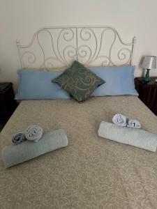 a bed with two rolled up towels on it at Casa Ortensia in Santa Teresa di Riva