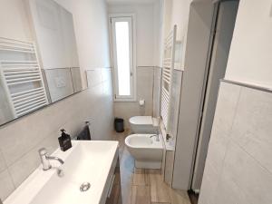 a white bathroom with a sink and a toilet at Bologna Holiday House in Bologna