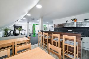 a restaurant with wooden tables and chairs and a bar at Apartmány Jakub in Příseka
