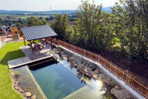 an overhead view of a swimming pool with a wooden bridge at Apartmány Jakub in Příseka