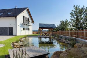 a garden with a pond and a gazebo at Apartmány Jakub in Příseka