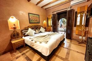 a bedroom with a large bed in a room at DAR SMAWAR top piscine chauffée 15mn centre ville in El Caïd Omar +63 photos