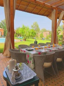 a table with plates and glasses on it on a patio at DAR SMAWAR top piscine chauffée 15mn centre ville in El Caïd Omar