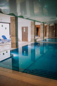 una piscina con agua azul en un edificio en Pensiunea Smida Park, en Smida