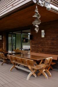 Una mesa de madera y bancos en un patio. en Pensiunea Smida Park, en Smida