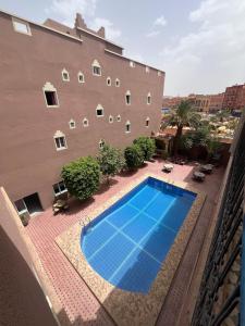 ein Schwimmbad vor einem Gebäude in der Unterkunft Hôtel Zaghro in Ouarzazate