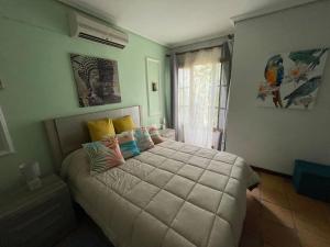 ein Schlafzimmer mit einem großen Bett mit bunten Kissen in der Unterkunft Magnifico Bungalow 2 plantas 110 m,con 3 piscinas in San Fernando