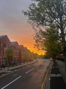 an empty street with a sunset in the background at X marina breeze x in Swansea