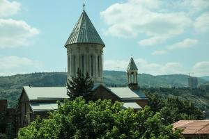 a building with a tower and a church with a steeple at Hotel Voyager in Tbilisi City