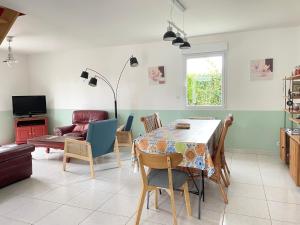 un soggiorno con tavolo da pranzo e sedie di Sweet Omaha Belle maison récente lumineuse et cosy bien équipée jardin clos 15 mn à pied plage Omaha Beach et proche de Bayeux & Port en Bessin a Saint-Laurent-sur-Mer
