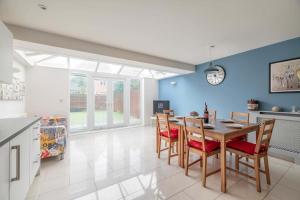 a kitchen and dining room with a table and chairs at Modern Home - Slough, Heathrow, Pinewood - Parking in Langley Marish