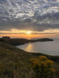 卡兰斯拓克Shamrock's Cove - Cornwall Coastal Winter Retreat的日落在水体上,日落在太阳下