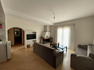 a living room with a couch and a television at The Countryside in Sarandë