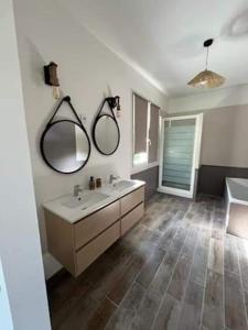 a bathroom with a sink and two mirrors on the wall at Nel Home in Mazan
