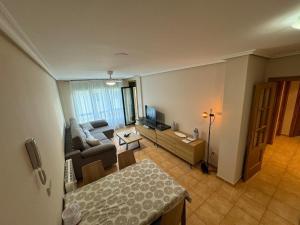 Una sala de estar con un sofá y un televisor. en Apartamento VILLA ANDRES, en Villadaíde