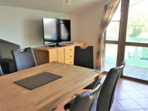 einen Esstisch mit Stühlen und einen TV in der Unterkunft Zeesenhaus 06 in Ostseebad Sellin + 14 Fotos