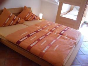 ein Bett mit einer orangefarbenen Decke darüber in der Unterkunft Zeesenhaus 06 in Ostseebad Sellin