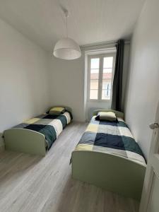 La Maison de l'Estuaire في سانت-إستيف: سريرين يجلسون في غرفة مع نافذة